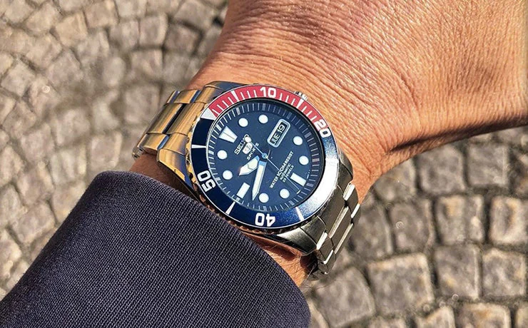 Seiko SNZF15K1 Sea Urchin Pepsi на руке — сине-красный безель, фон брусчатки