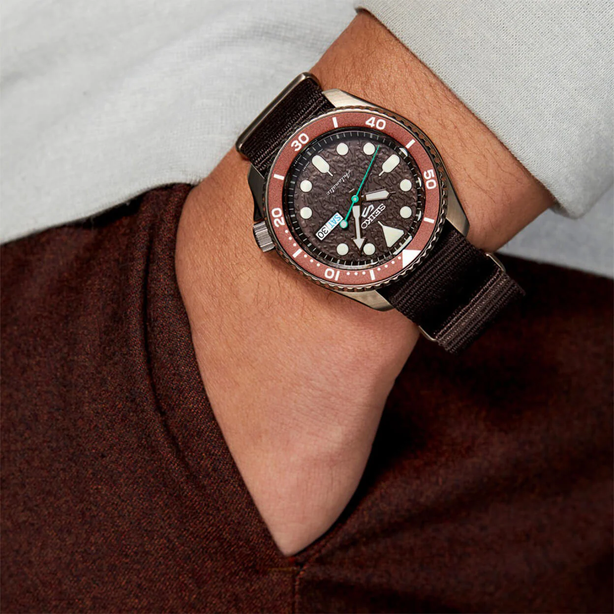 Seiko SRPD85K1 на руке — коричневый циферблат, ремешок NATO, бордовый свитер